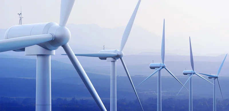 Windkraftanlagen vor einer bergigen Landschaft